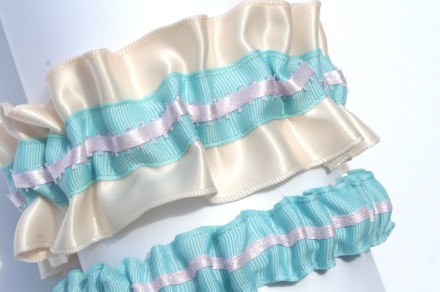 The tossing garter is turquoise grosgrain with a light pink satin stripe